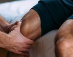 physician performing sports recovery massage in knee injury